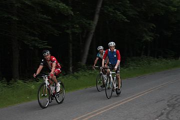 Cyclist riding past rock cliff